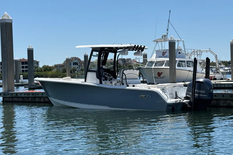 Slide: The Image of 2021 Sea Hunt Ultra 239 SE boat docked in marina, clear blue sky. - 25