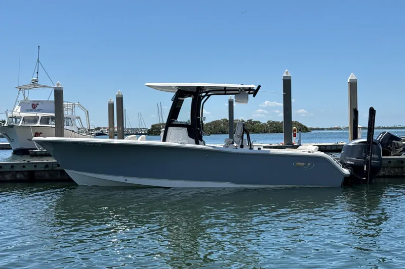 Slide: The Image of 2021 Sea Hunt Ultra 239 SE boat docked in a marina under clear blue skies. - 26