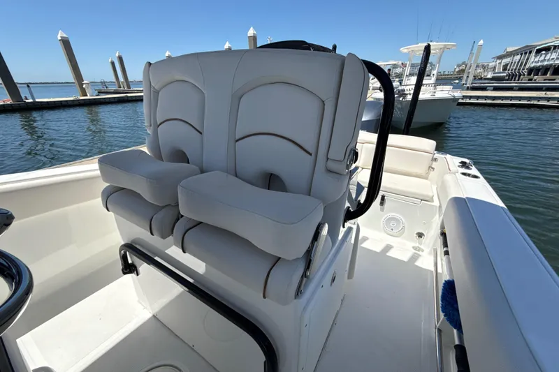 Slide: The Image of 2021 Sea Hunt Ultra 239 SE boat interior with dual seats at marina. - 7