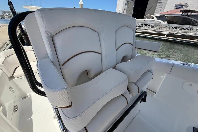 Slide: The Image of 2021 Sea Hunt Ultra 239 SE boat seating with white upholstery at a marina. - 8