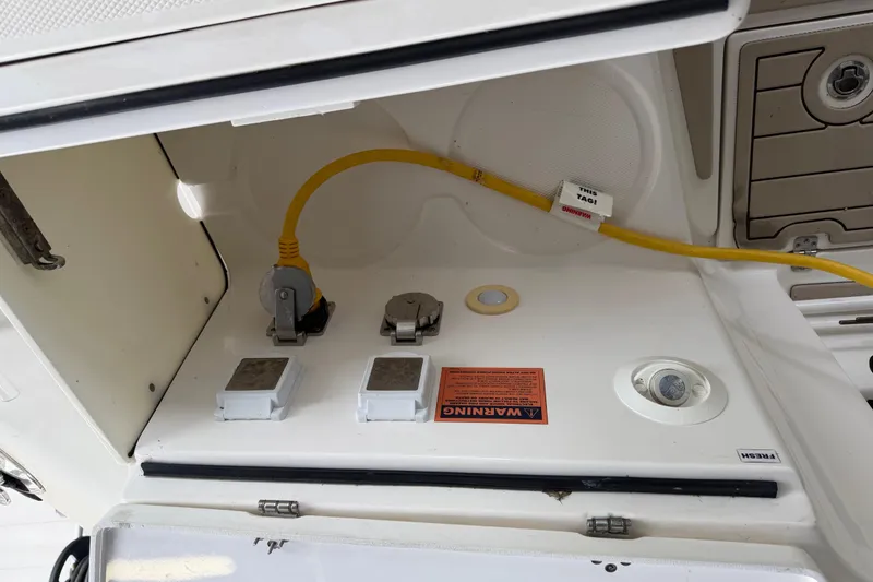 Slide: The Image of 2017 Edgewater 368CC boat electrical compartment with yellow cable and warning label. - 12