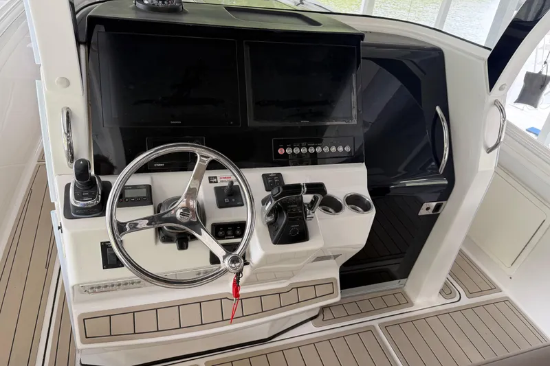 Slide: The Image of 2017 Edgewater 368CC boat helm with steering wheel, controls, and dual displays. - 3