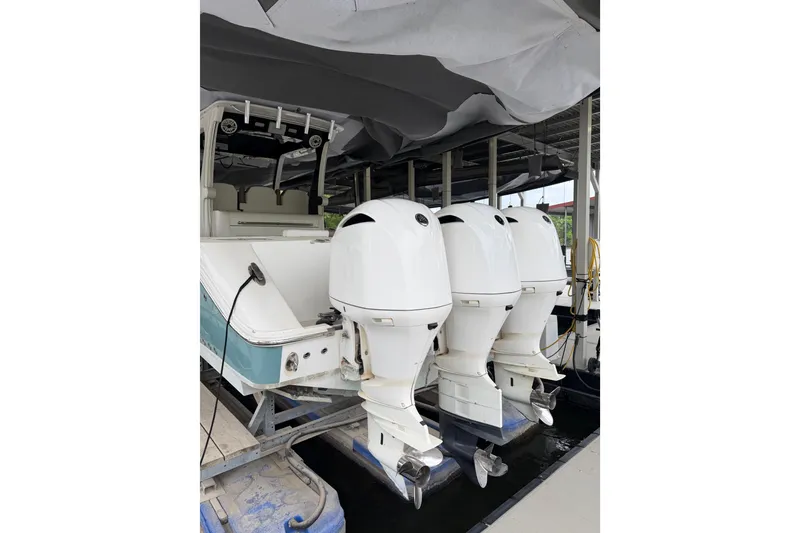 Slide: The Image of 2017 Edgewater 368CC boat with triple outboard engines docked under cover. - 5