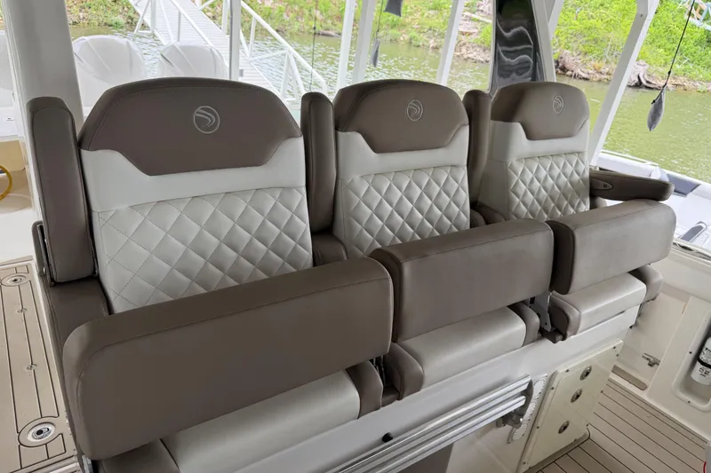 Slide: The Image of Luxurious seating on a 2017 Edgewater 368CC boat, featuring quilted upholstery and armrests. - 7