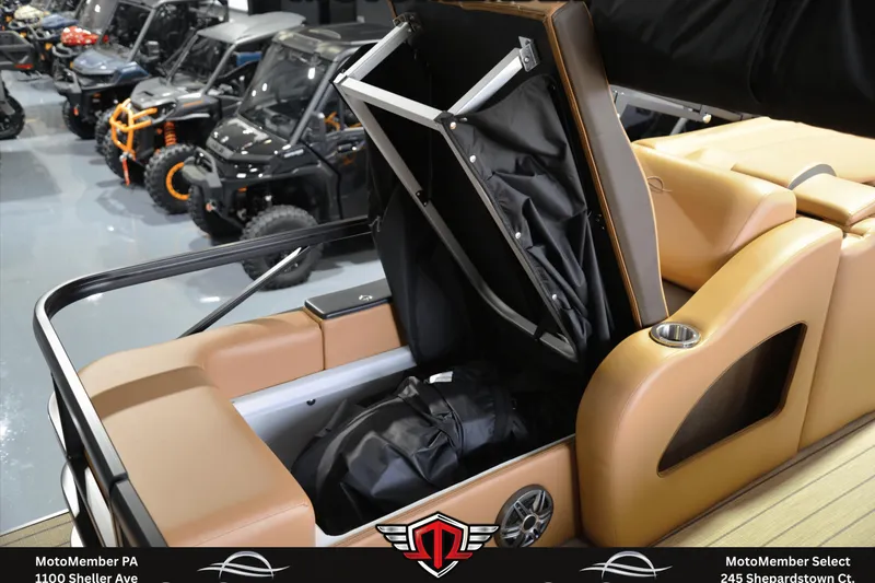 Slide: The Image of 2025 SunCatcher Fusion 324SS boat interior with storage compartment open, showcasing seating and cup holder. - 7