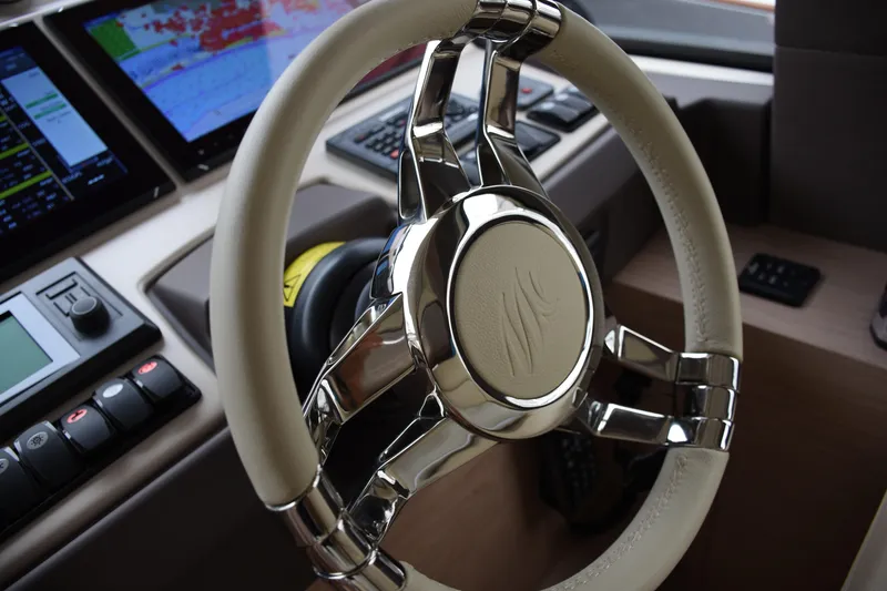 Slide: The Image of Steering wheel of a 2016 Beneteau Monte Carlo 5 yacht, featuring advanced navigation controls. - 13