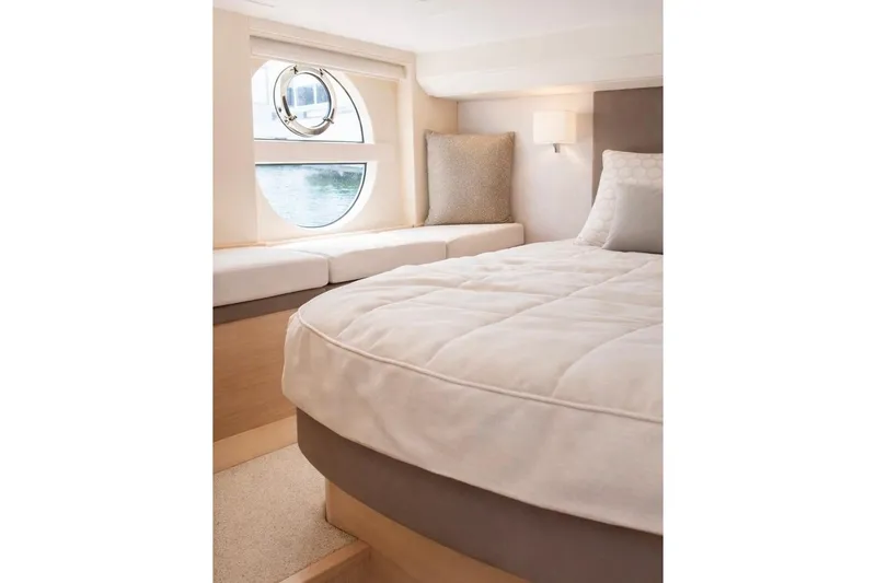 Slide: The Image of Luxurious bedroom interior of 2016 Beneteau Monte Carlo 5 yacht with round window. - 2