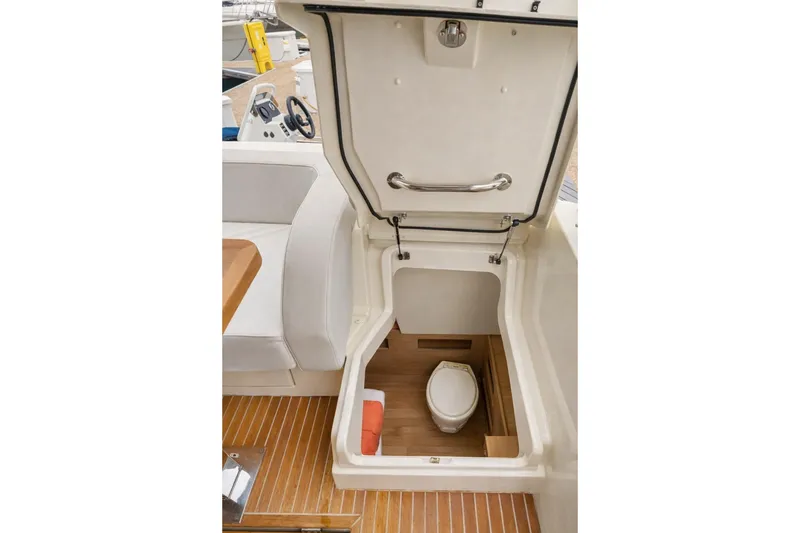 Slide: The Image of Interior view of 2016 Beneteau Monte Carlo 5 yacht, featuring a compact marine toilet. - 5