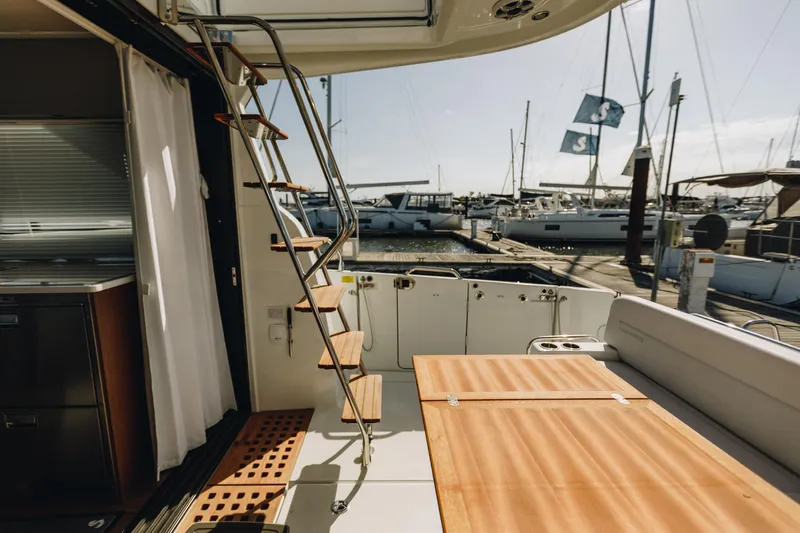 Slide: The Image of Interior view of 2026 Beneteau Antares 12 Fly yacht, featuring elegant seating and marina backdrop. - 10