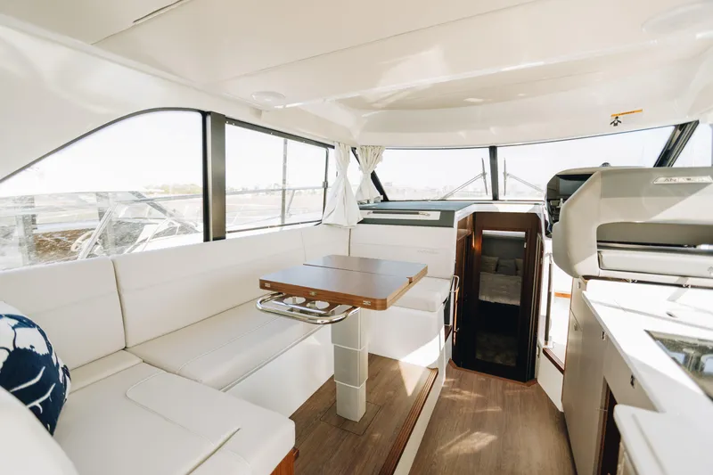 Slide: The Image of Luxurious interior of 2026 Beneteau Antares 12 Fly yacht with modern seating and dining area. - 11