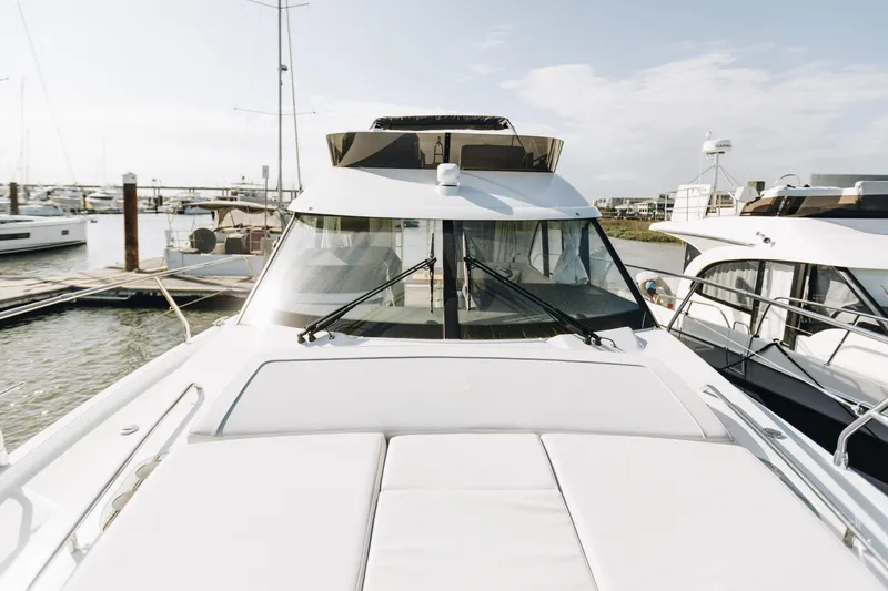 Slide: The Image of 2026 Beneteau Antares 12 Fly yacht docked at marina under clear sky. - 2