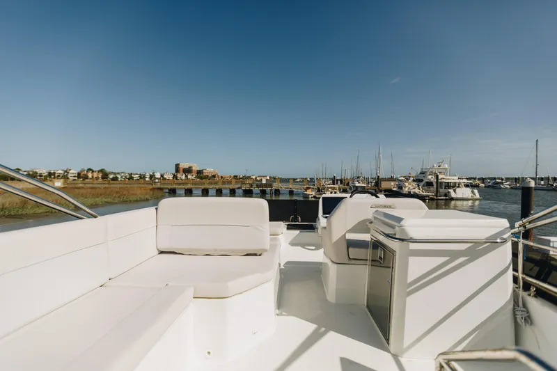 Slide: The Image of 2026 Beneteau Antares 12 Fly yacht interior with marina view, featuring sleek white seating. - 3