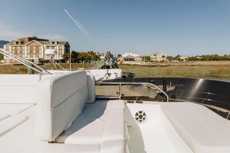 Slide: The Image of 2026 Beneteau Antares 12 Fly yacht with luxurious seating, docked near waterfront buildings. - 6