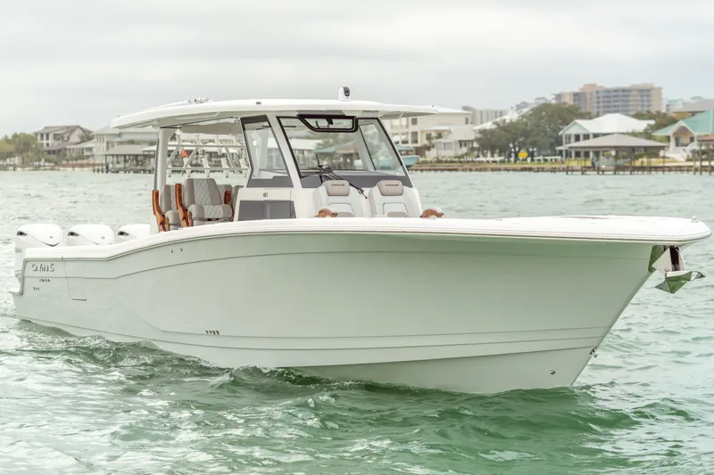 Slide: The Image of Caymas 401 DR 2027 boat on calm water with coastal background. - 3