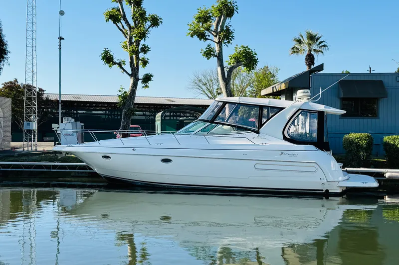 Slide: The Image of 2000 Cruisers Yachts 3575 Express docked by a marina, reflecting on calm water. - 12