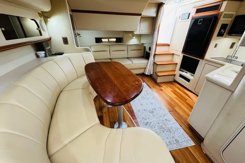 Slide: The Image of Interior of 2000 Cruisers Yachts 3575 Express with elegant seating and wooden table. - 48