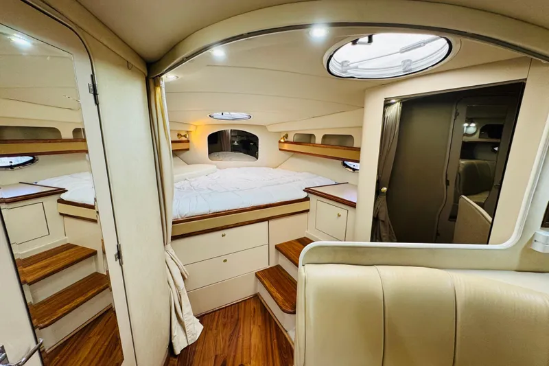 Slide: The Image of Interior of 2000 Cruisers Yachts 3575 Express, featuring cozy cabin and wooden accents. - 49