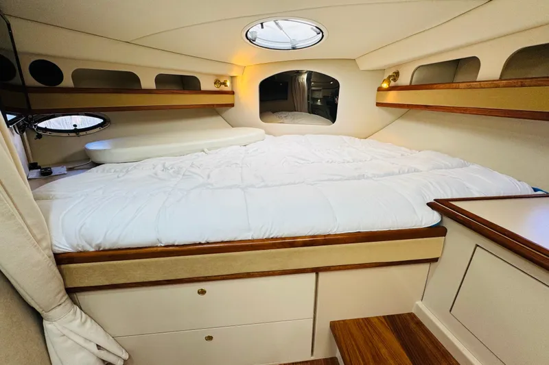 Slide: The Image of Luxurious cabin interior of 2000 Cruisers Yachts 3575 Express with cozy bedding and elegant wood accents. - 50