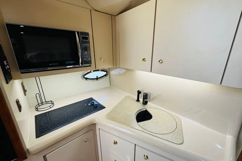 Slide: The Image of Compact kitchen in 2000 Cruisers Yachts 3575 Express with microwave, stove, and sink. - 55