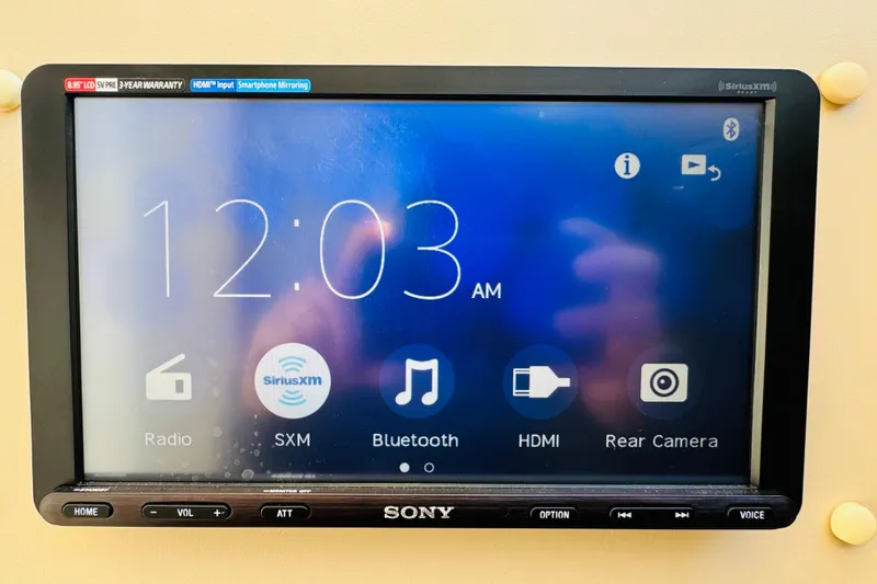 Slide: The Image of Sony touchscreen display on a 2000 Cruisers Yachts 3575 Express, showing time and media options. - 58