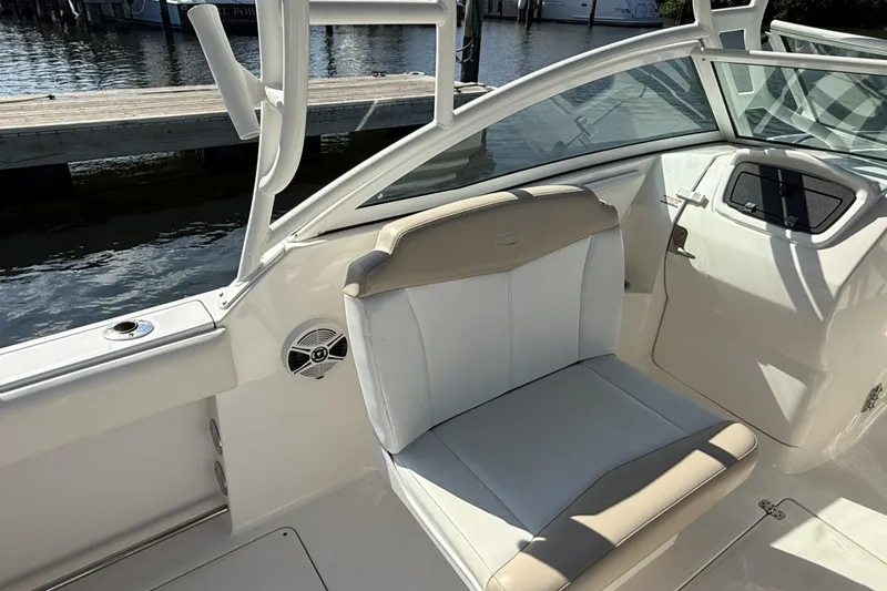 Slide: The Image of 2018 Robalo R247 Dual Console boat interior with beige and white seating. - 6