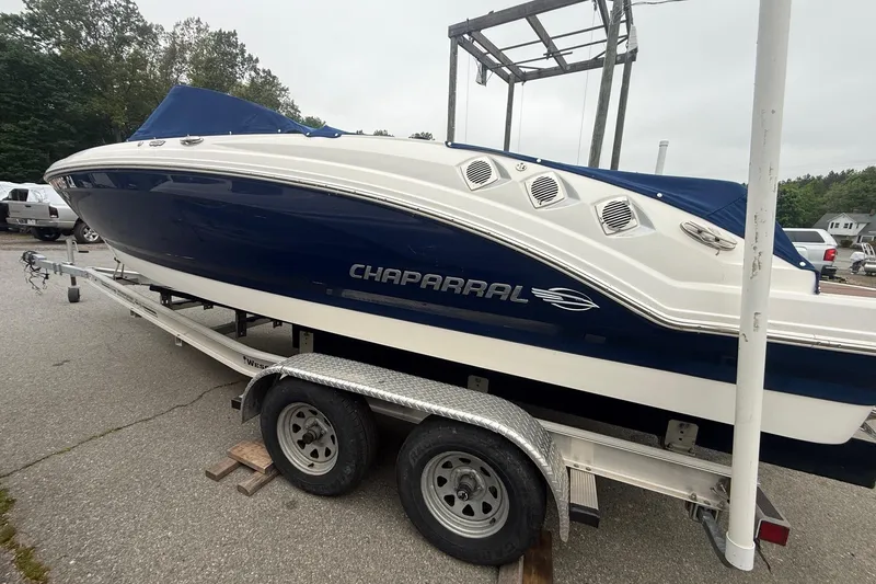The Image of 2016 Chaparral 226 SSi Wide Tech boat on trailer, blue and white design. - 1