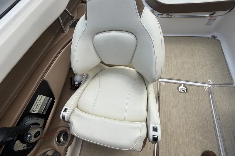 Slide: The Image of 2016 Chaparral 226 SSi Wide Tech boat interior with white captain's chair and beige flooring. - 15