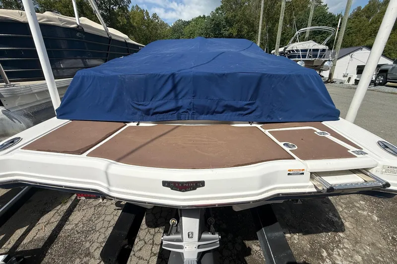 Slide: The Image of 2016 Chaparral 226 SSi Wide Tech boat with blue cover, docked outdoors. - 26