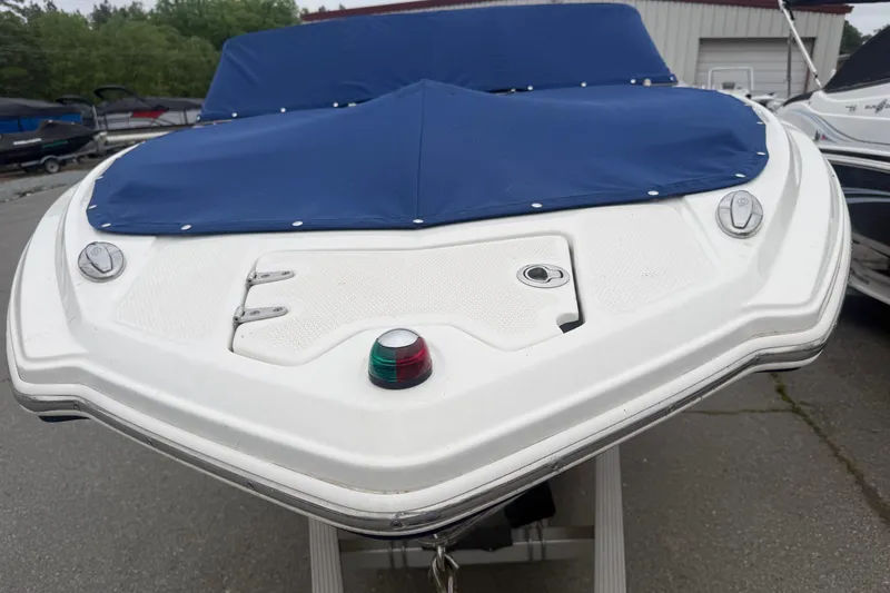 Slide: The Image of 2016 Chaparral 226 SSi Wide Tech boat with blue cover, docked outdoors. - 5