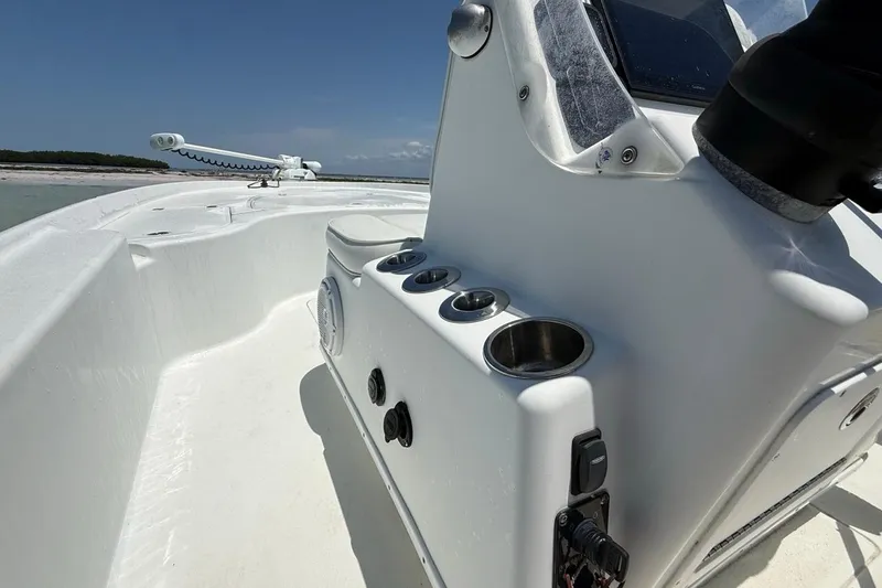 Slide: The Image of 2013 Yellowfin 21 Bay boat interior with console and cup holders, under clear blue sky. - 15