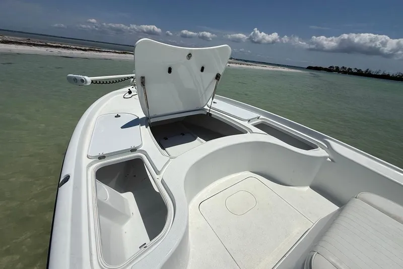 Slide: The Image of 2013 Yellowfin 21 Bay boat with open storage compartments, docked in clear coastal waters. - 19