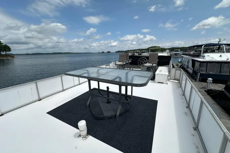 Slide: The Image of Rooftop deck of 1990 Lazy Days 14x72 houseboat with table and chairs, overlooking serene lake. - 15