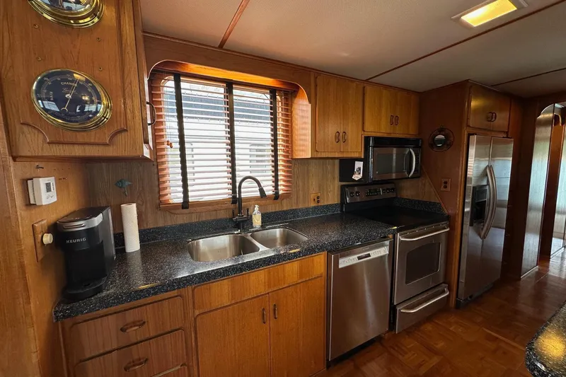 Slide: The Image of Kitchen interior of a 1990 Lazy Days 14x72 houseboat with wood cabinets and stainless steel appliances. - 4