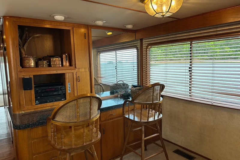 Slide: The Image of Interior of a 1990 Lazy Days 14x72 houseboat with wooden cabinetry and bar stools. - 5