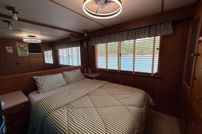 Slide: The Image of Cozy bedroom in 1990 Lazy Days 14x72 houseboat with striped bedding and scenic window view. - 6