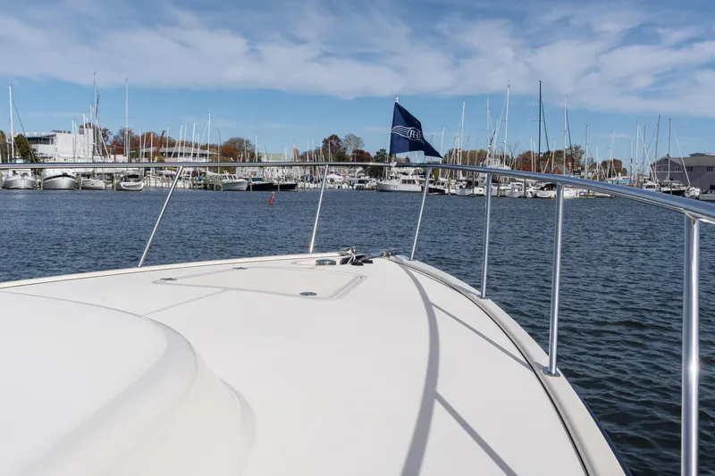 Slide: The Image of 2016 Palm Beach Motor Yachts PB50 on water, marina in background, clear sky. - 27