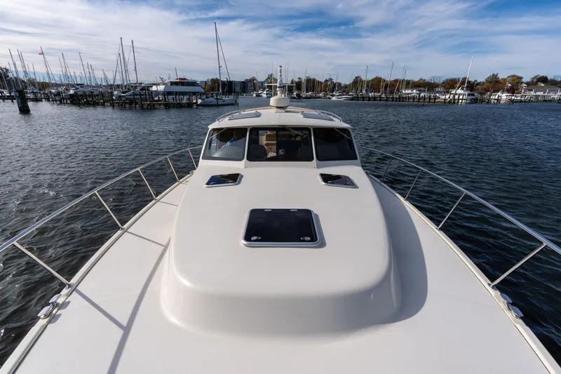 Slide: The Image of 2016 Palm Beach Motor Yachts PB50 on calm waters, marina in background. - 29