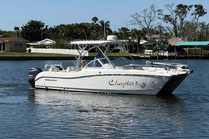 The Image of 2017 World Cat 255 DC boat named "Chapter 2" cruising on a calm waterway. - 0