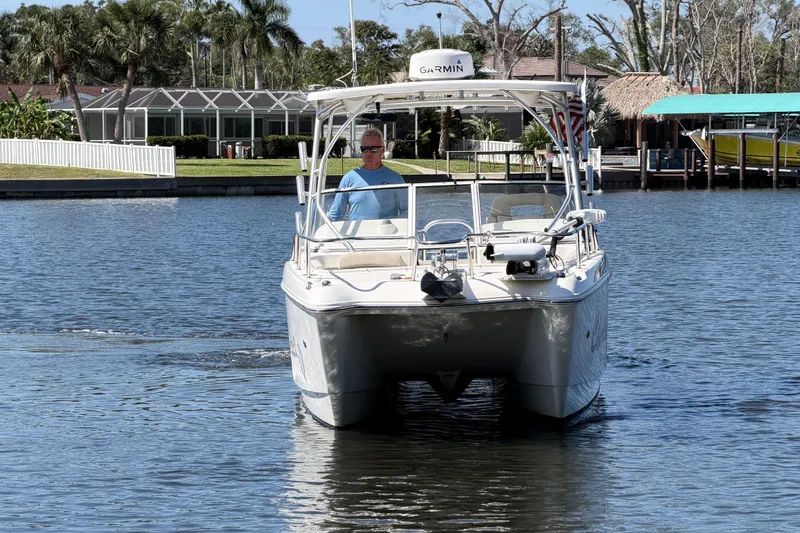 Slide: The Image of 2017 World Cat 255 DC boat cruising on a calm waterway with a scenic backdrop. - 15