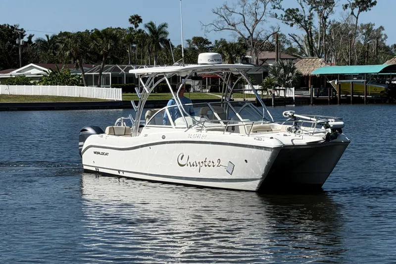Slide: The Image of 2017 World Cat 255 DC boat cruising on a calm waterway, surrounded by lush greenery. - 17