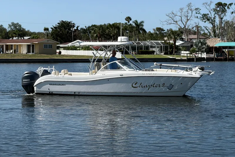 Slide: The Image of 2017 World Cat 255 DC boat named "Chapter 2" cruising on a calm waterway. - 18