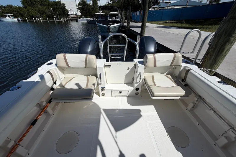 Slide: The Image of 2017 World Cat 255 DC boat interior with seating, docked by the water. - 2