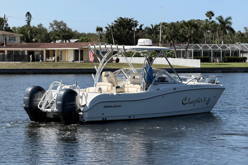 Slide: The Image of 2017 World Cat 255 DC boat cruising on a calm waterway near residential area. - 21