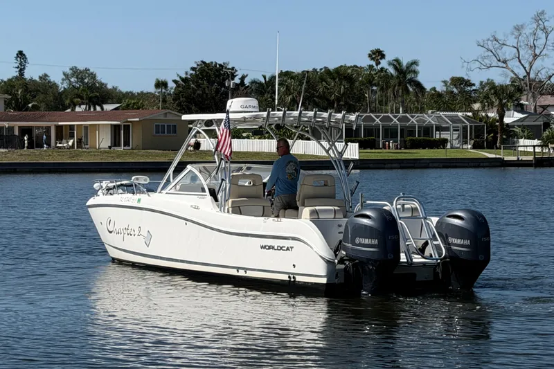 Slide: The Image of 2017 World Cat 255 DC boat on water with dual Yamaha engines, American flag displayed. - 24
