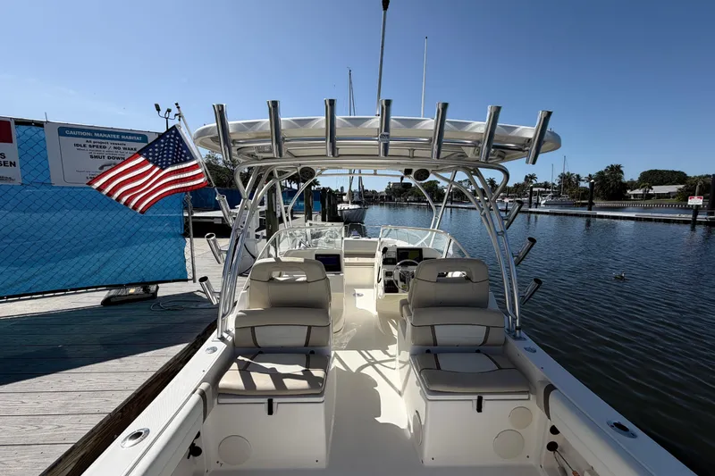 Slide: The Image of 2017 World Cat 255 DC boat docked, featuring seating and American flag, under clear blue sky. - 3