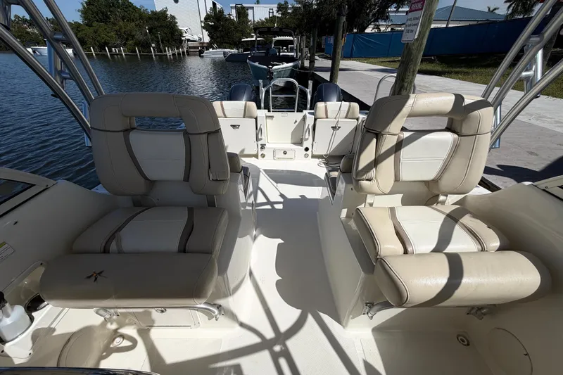 Slide: The Image of 2017 World Cat 255 DC boat interior with beige seating and waterfront view. - 6