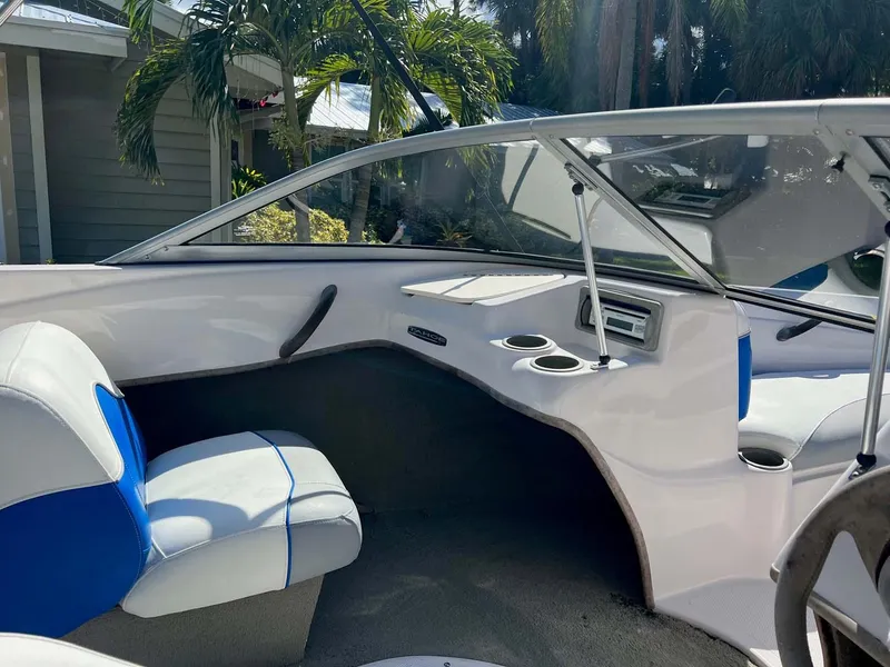 Slide: The Image of 2005 Tahoe T18 Ski Boat interior with blue and white seating, cup holders, and dashboard. - 13
