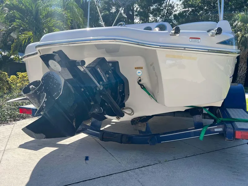 Slide: The Image of 2005 Tahoe T18 Ski Boat on trailer, rear view with outboard motor, sunny day. - 17