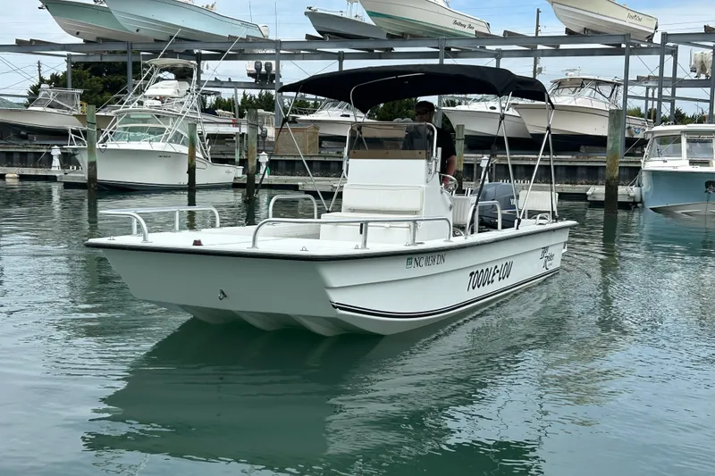 Slide: The Image of 2009 KenCraft 2060 boat docked in marina, featuring sleek design and canopy. - 11
