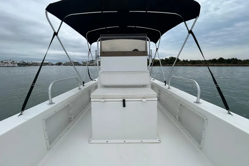 Slide: The Image of 2009 KenCraft 2060 boat with canopy, docked on calm waters under cloudy skies. - 16